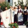 Zászlóanya Kovács Ilona felköti a zászlóra a millenniumi szalago